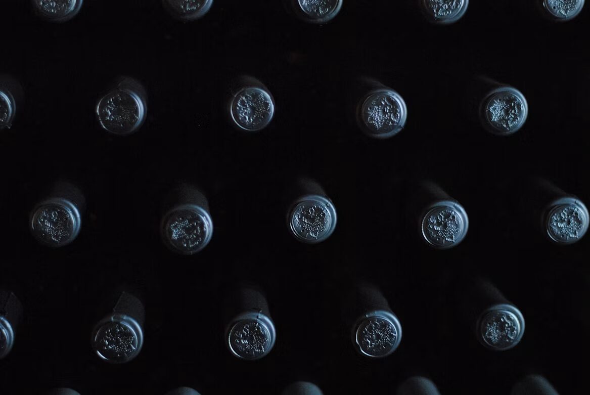 Rows of fine wine bottles seen from below in dramatic light